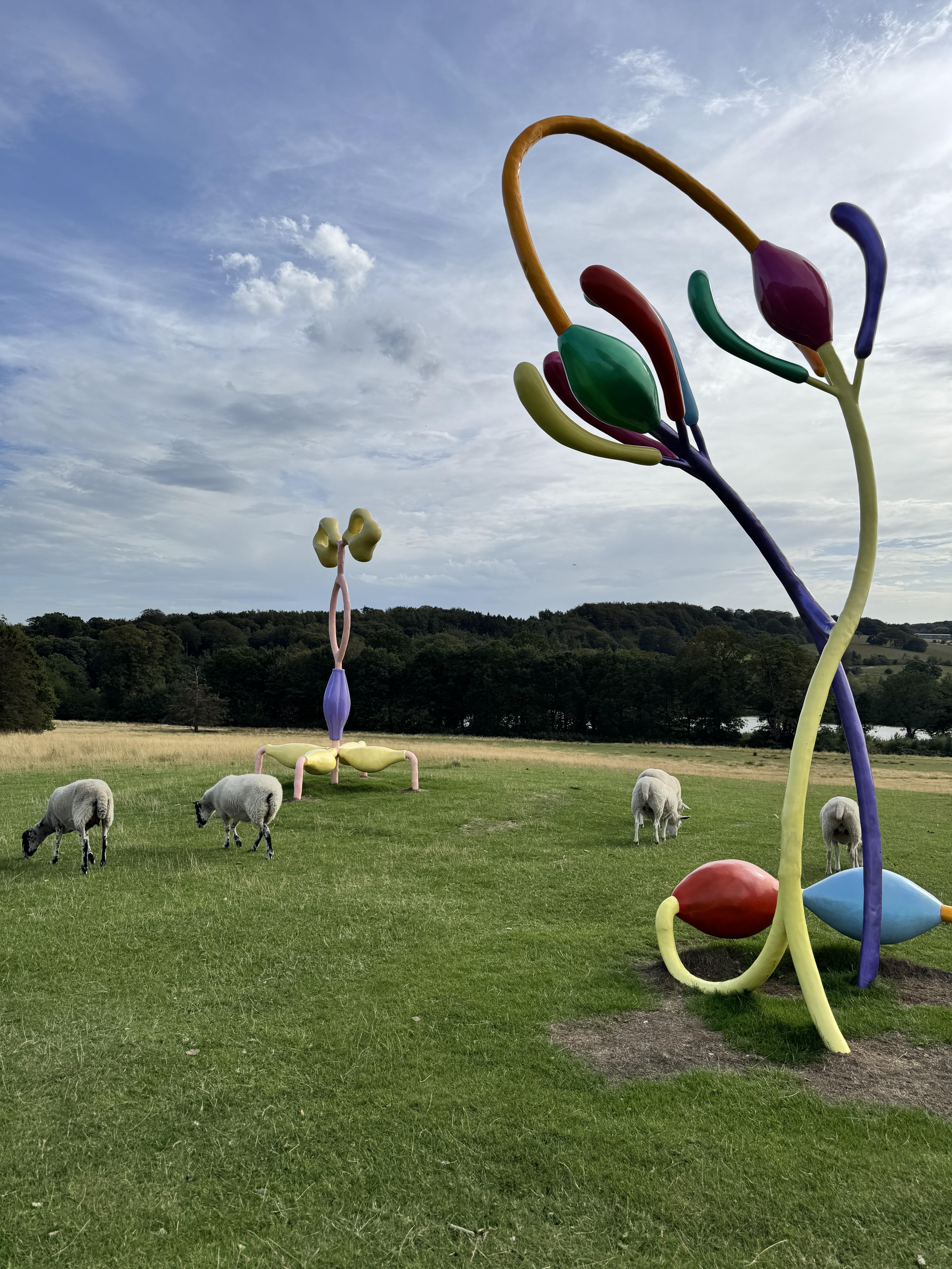 Colorful outdoor sculptures among grazing sheep at Yorkshire Sculpture Park